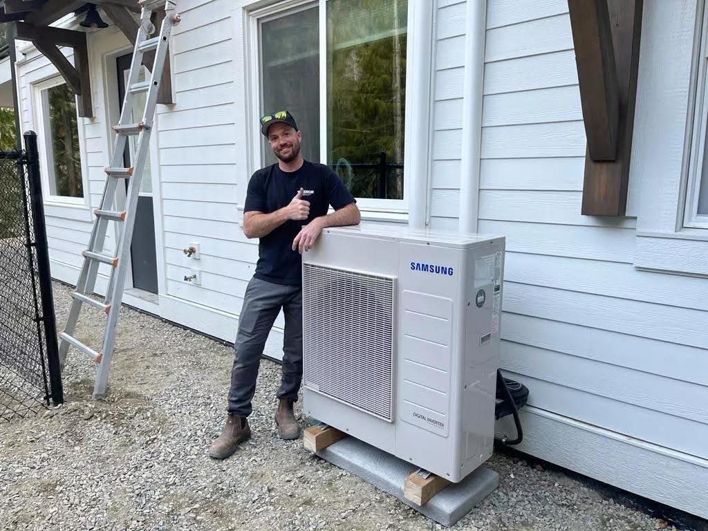 New ductless outdoor unit set on a pad next to a house