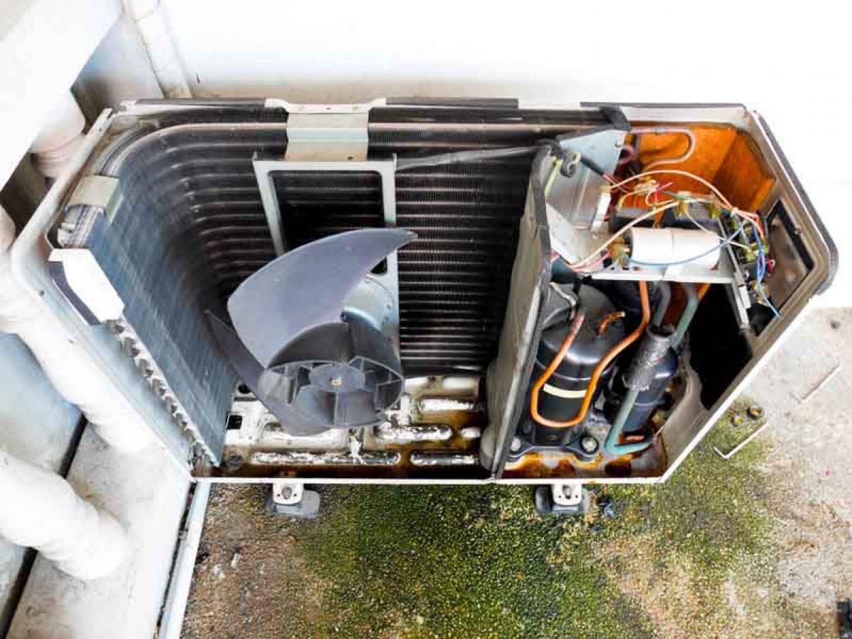 Open outdoor condenser showing fan, coil, and compressor during service