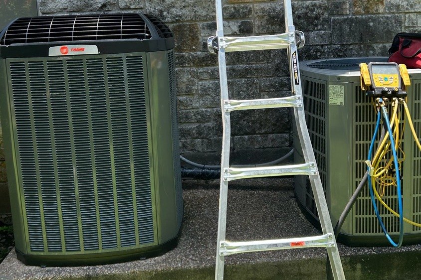 Full system changeout at an Austin limestone home — new Trane condenser set and the second unit on gauges